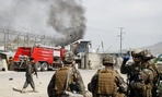 NATO soldiers watch smoke billow after a Talban attack Wednesday in Kabul.