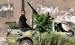 Syrian rebels patrol Khaldiyeh neighborhood, in Homs province.