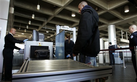 A  Homeland Security screener looks at an X-ray scan of a suitcase of a train passenger in 2006.
