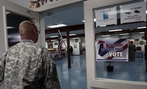 U.S. Army soldier member of the NATO-led peacekeeping force in Kosovo walks by a poster urging soldiers to vote Nov. 2.