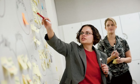 OPM's Sarah Hassmer (left) and Cassie Cunfer facilitate a stakeholder mapping exercise in problem solving.