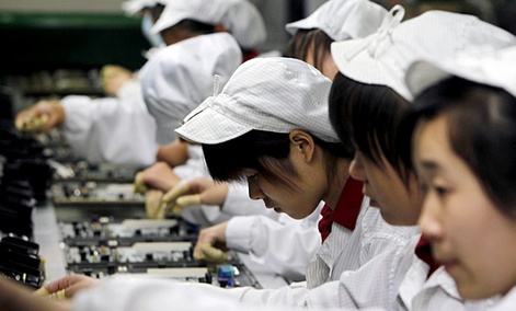 Staff members work on the production line making Apple products at the Foxconn complex in Shenzhen, China
