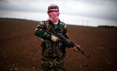 A Free Syrian Army fighter takes position close to a military base, near Azaz, Syria.