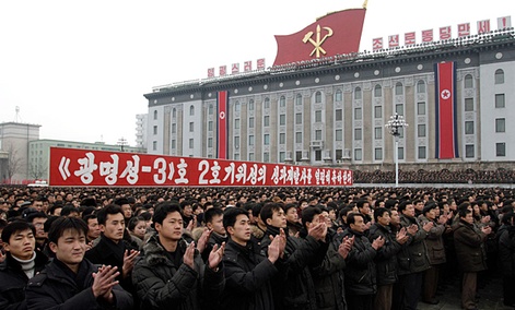 North Koreans applaud near a slogan which reads “(we) fervently celebrate the successful launch of the second version of the Kwangmyongsong-3 satellite 2nd version" during a mass rally in Pyongyang.