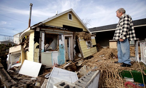 Joe Vanvaketis looks at his home from what used to be the stoop of his back door in the Oakwood Beach section of Staten Island, New York.