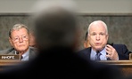 Sen. John McCain, R-Ariz., right, asks a question of former Nebraska Sen. Chuck Hagel.