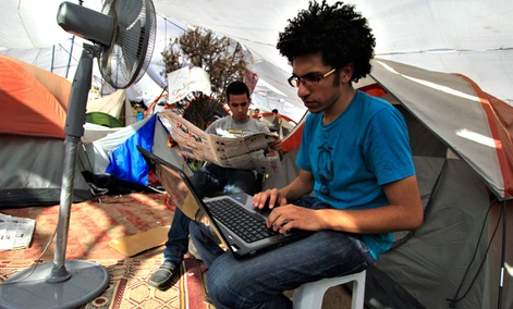 An Egyptian protester uses his laptop next to a cooling fan in Cairo's Tahrir Square in July 2011. 
