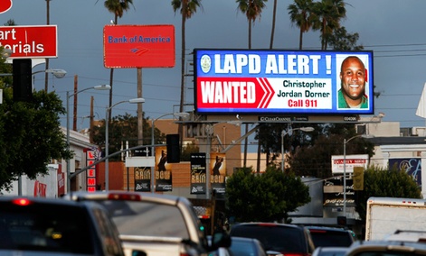 A digital billboard shows a "wanted" alert for former Los Angeles police officer Christopher Dorner.