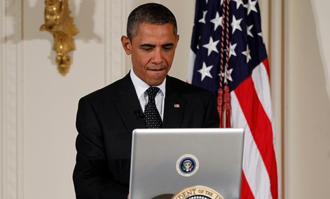 President Barack Obama uses a laptop computer to send a tweet during a "Twitter Town Hall."