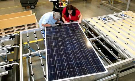 Stacey Rassas, right, a quality control manager at a Suntech Power Holdings Co., a Chinese-owned solar panel manufacturer, examines a solar panel.