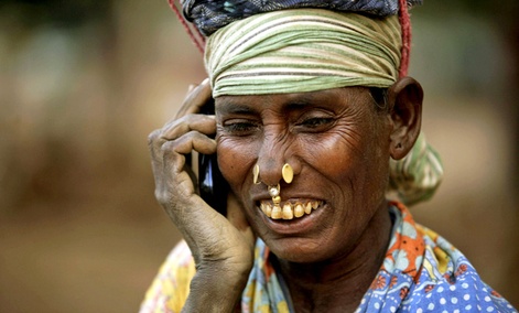 An Indian daily wage laborer talks on a mobile phone, at a construction site in Bhubaneshwar, India.