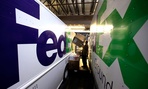 Workers sort packages at a FedEx sorting facility in Kansas City, Mo. 