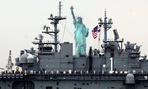 Sailors line the deck of the USS Wasp as she sails by the Statue Of Liberty, in New York, to participate in 2012 Fleet Week activities,