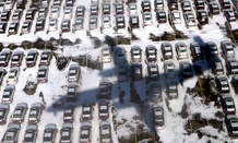 Continental Airlines flight 3306 from Toronto casts a shadow over a snow covered parking lot as it approaches Newark airport in Newark, New Jersey.