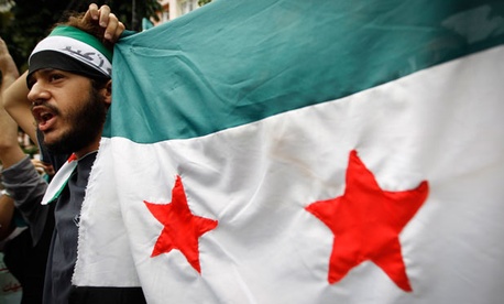 A man holds up a Syrian flag at a recent Malaysian protest of the current Syrian regime. A man holds up a Syrian flag at a recent Malaysian protest of the current Syrian regime.