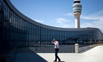 The control tower stands in the background as a passenger paces while on the phone outside the international terminal at Hartsfield-Jackson airport. The control tower stands in the background as a passenger paces while on the phone outside the international terminal at Hartsfield-Jackson airport.
