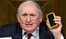 Sen. Carl Levin, D-Mich. holds up his own Apple iPhone while questioning Apple CEO Tim Cook.