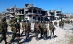 Syrian soldiers loyal to President Bashar Assad in the town of Qusair patrol in early June.