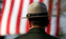 A National Park ranger stands near a giant U.S. flag over the processional route before a memorial service for Mount Rainier National Park Ranger Margaret Anderson on Jan. 10, 2012.