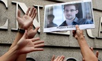 A supporter holds a picture of Edward Snowden, outside the U.S. Consulate General in Hong Kong. 