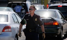A Customs and Border Protection officer walks through a line of cars at a crossing from Canada near Blaine, Wash.