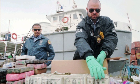 Agents prepare money seized in a drug bust. Agents prepare money seized in a drug bust.