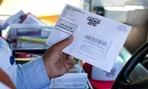 A Postal Service employee holds a 2010 census form.