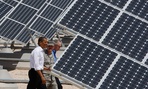 Barack Obama, Sen. Harry Reid, D-Nev.,  and Col. Howard Belote tour solar power panels at Nellis Air Force Base in 2009.