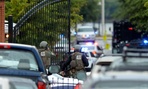 Law enforcement personnel walk through a gate into the Washington Navy Yard. 