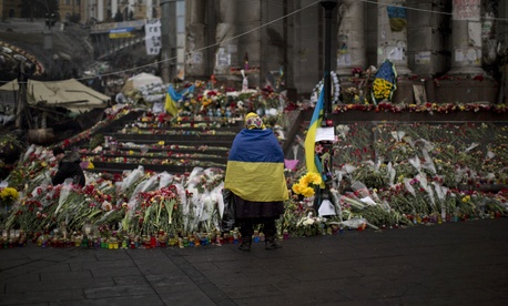 A woman rests by a memorial in Kiev. A woman rests by a memorial in Kiev.