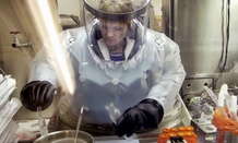 A microbiologist at Life Sciences Test Facility at Dugway Proving Ground, Utah, works in a specialized airtight enclosure designed for use with deadly agents. 