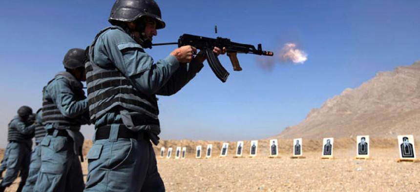 Afghan police recruits practice shooting at a firing range.