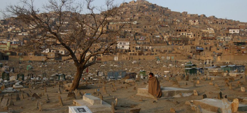 A man sits in a cemetery in Kabul in January.