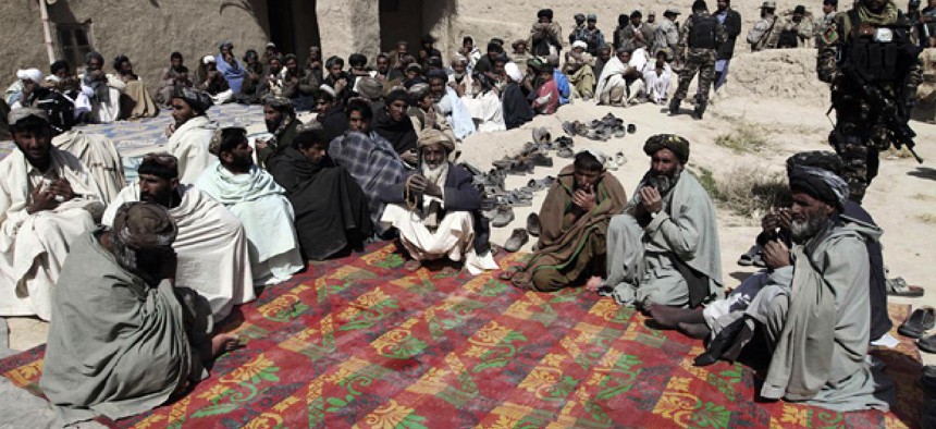 Afghan villagers pray during a ceremony Sunday for the civilians shot by a U.S. soldier in Kandahar.