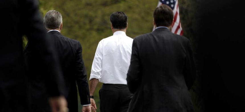 Mitt Romney walks with Secret Service agents.