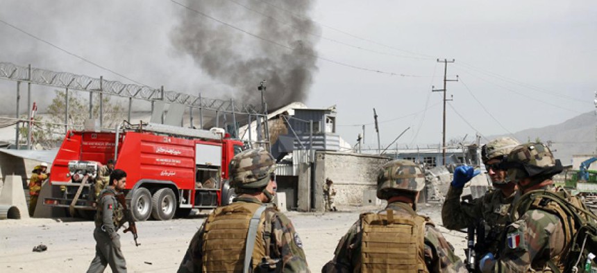 NATO soldiers watch smoke billow after a Talban attack Wednesday in Kabul.