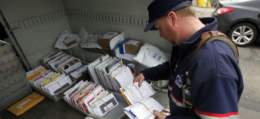 A Philadelphia postal worker sorts mail in his truck.