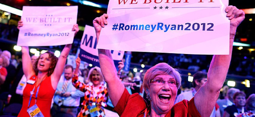 Georgia delegates Ruby Robinson, right, and Kathy Noble, left, hold up signs and cheer during the Republican National Convention in Tampa, Fla.