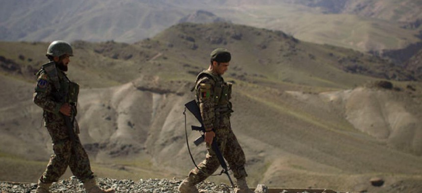 Two Afghan soldiers walk toward their outpost in Logar province in May.