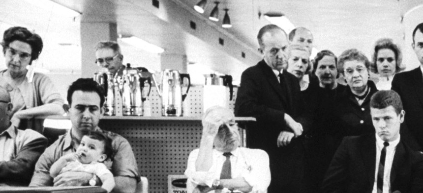 Customers in a California department store watch President Kennedy’s televised address to the nation, as he informs the American people about the unfolding crisis in Cuba, October 22, 1962 Photograph by Ralph Crane 