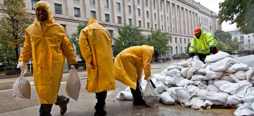 Workers haul sandbags in front of the Justice Department.