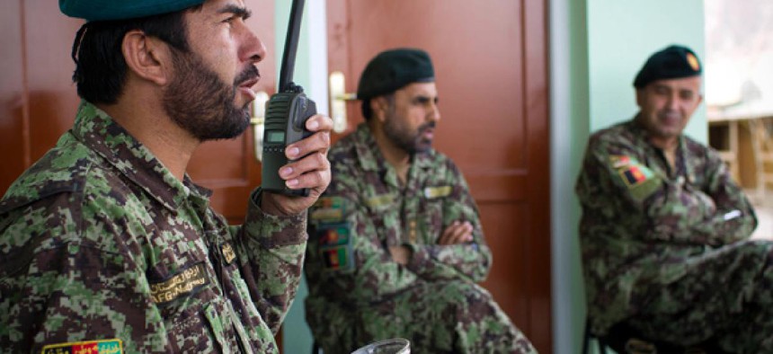 Afghan National Army Lt. Col. Abdul Wakil Warzejy, left, gives orders on his radio at his base in Logar province.