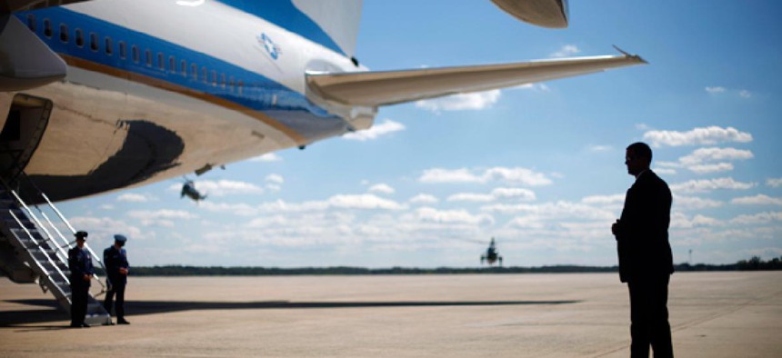 A Secret Service agent stands at right underneath the wing of Air Force One.