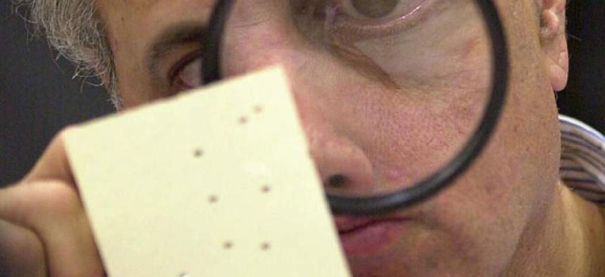 A Florida election worker inspects a ballot in 2000.
