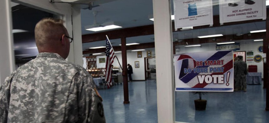 U.S. Army soldier member of the NATO-led peacekeeping force in Kosovo walks by a poster urging soldiers to vote Nov. 2.