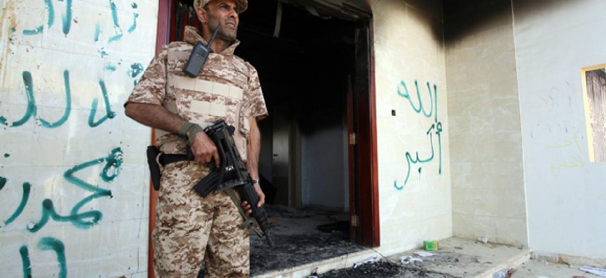 A Libyan military guard stands in front of one of the U.S. Consulate's burnt out buildings.