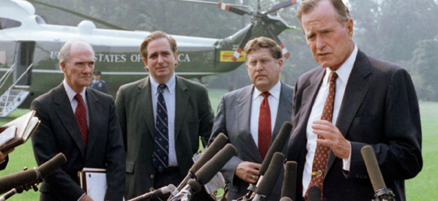 U.S. President George H. W. Bush talks with reporters on the White House lawn, Friday, Sept. 7, 1990 in Washington before flying to Andrews Air Force Base, Md. with his key aides to attend a budget negotiating session with congressional leaders