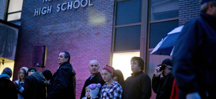 People wait in line to attend a memorial at Newtown High School Sunday.