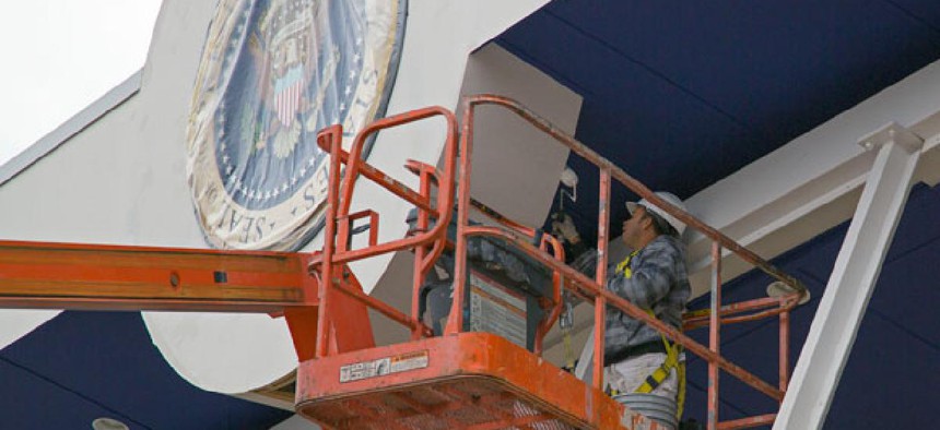 A painter works on the presidential viewing stand outside the White House in preparation for the inauguration. 