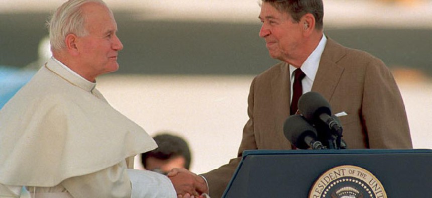 U.S. President Ronald Reagan shakes hands with Pope John Paul II on the podium at Miami International Airport, Fla., on Sept. 10, 1987. 